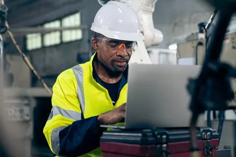 Factory worker working with laptop computer to do adept procedure checklist Stock Photos