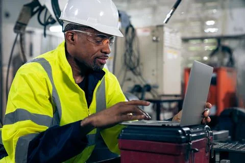 Factory worker working with laptop computer to do adept procedure checklist Stock Photos