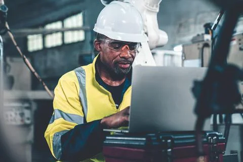 Factory worker working with laptop computer to do adept procedure checklist Stock Photos