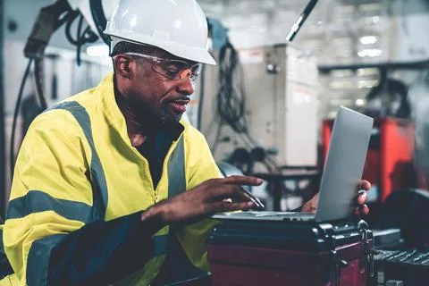 Factory worker working with laptop computer to do adept procedure checklist Stock Photos