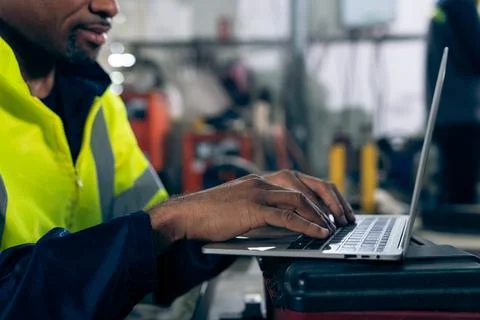 Factory worker working with laptop computer to do adept procedure checklist Stock Photos