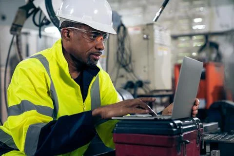 Factory worker working with laptop computer to do adept procedure checklist Stock Photos