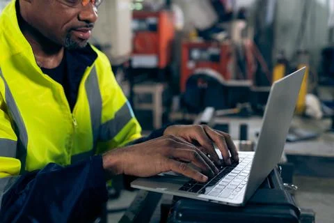Factory worker working with laptop computer to do adept procedure checklist Stock Photos