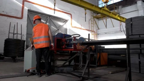 Factory worker working on a machine measuring and cutting steel cable Stock Footage 135314443