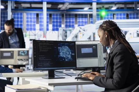 Factory worker writing AI code at workstation in photovoltaic plant Stock Photos