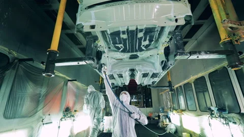 Factory workers are covering car bottom with anticorrosion agent Vídeo Stock 141120459