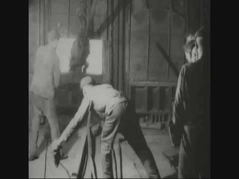 Factory workers are putting block in furnace - 1918 Stock Footage 83657558