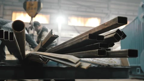 Factory workers attach metal pipes to a crane beam for their transportation. Stock Footage 313104242