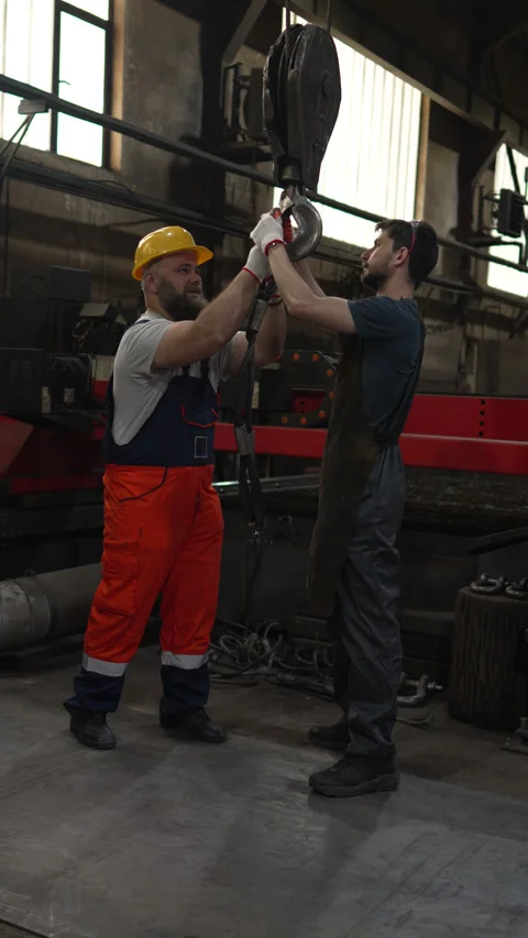 Factory workers collaborating on a crane hook Vidéo 334723253