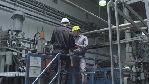 Factory workers discussing with each other in factory Stock Footage 106322325