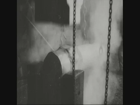 Factory workers putting block under machine to lower the block edge - 1918 Stock Footage 83657578