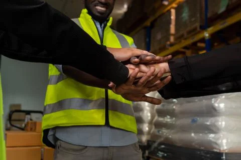 Factory workers stacking hands together in warehouse or storehouse Stock Photos