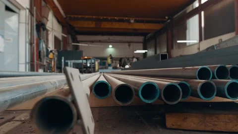 Factory ,workshop, warehouse, stacked up steel pipes with workers in the Stock Footage 150411093