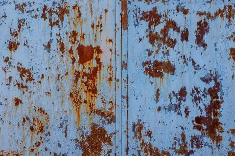 Faded blue paint on flat sheet steel surface with stains of rust - full-frame 库存照片