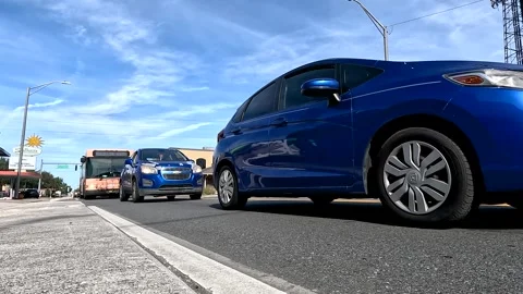 Faded orange bus passes and Traffic passing on Florida Ave blue sky modern .. Stock Footage 258046942