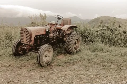 Faded retro image of an old tractor parked at the roadside Stock Photos