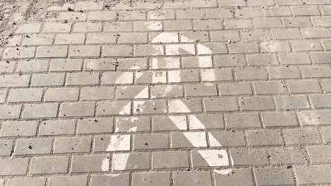 A faded white directional arrow on the brick pavement, the worn background  Stock Footage 331332006