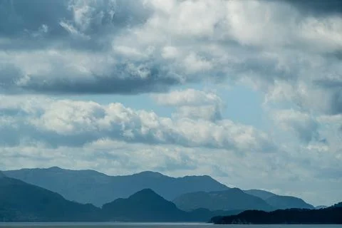 Fading blue hills and dramatic fair weather clouds in Norway 写真素材