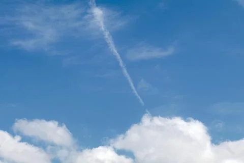 Fading jet trail in the clouds Stock Photos