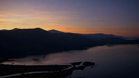 Fading orange light in the afterglow of sunset over lake land landscape. Stock Footage 118440105