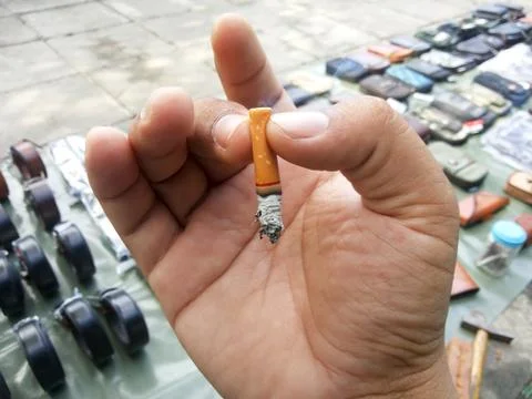Fag end in hand on isolated Stock Photos