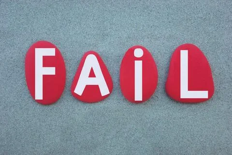 Fail, error message composed with hand painted red stone letters over green sand Stock Photos