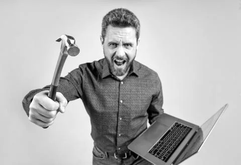 Failed to complete a task. Angry man shout holding hammer and laptop. Computer Stock Photos