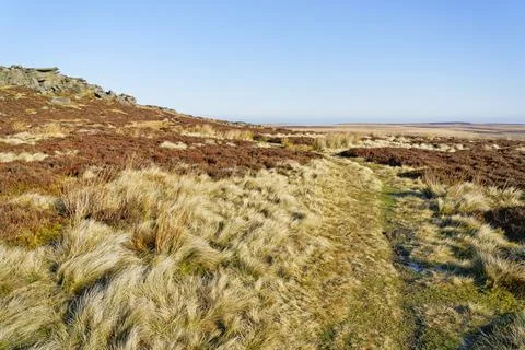 A faint footpath through the grass and heather runs along side Stanage Edge Stock Photos