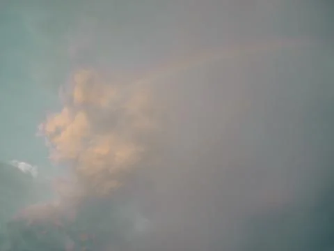 Faint Rainbow in Muted Grey-Teal Cloudy Sky, Subtle Weather Phenomenon Stock Photos