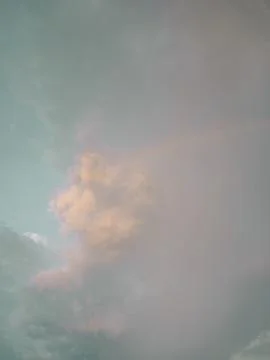 Faint Rainbow in Muted Grey-Teal Cloudy Sky, Subtle Weather Phenomenon Stock Photos