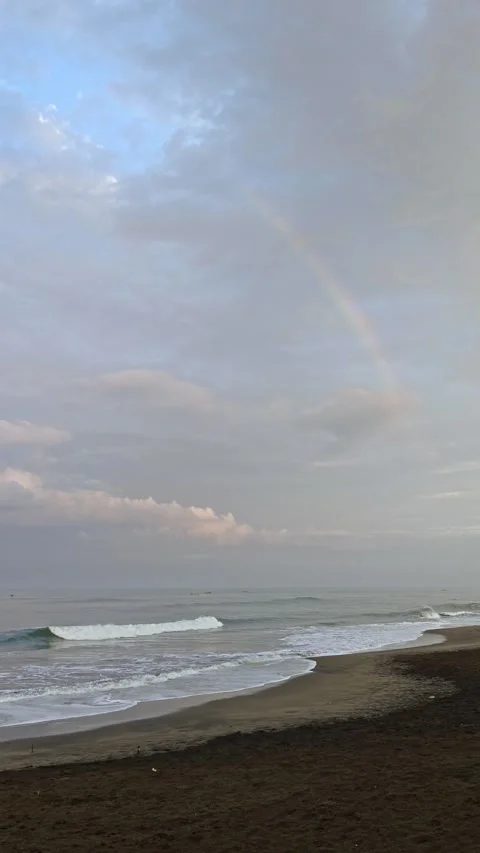 Faint Rainbow Over Ocean Waves and Sandy Beach at Dusk Stock Footage 341311984