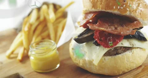 Faint spark appearing then green icons drifting over cheeseburger fries and jar Stock Footage 323370971