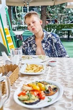 Fair-haired boy eats lunch at hotel restaurant on holiday 写真素材