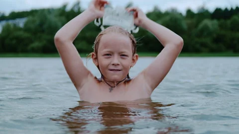 Fair Haired Boy Surfacing From Lake and Removing Mask Stock Footage 344679024