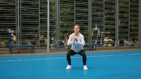 Fair-haired sporty lady doing sits-up during everyday workout outdoors Video stock 252195106