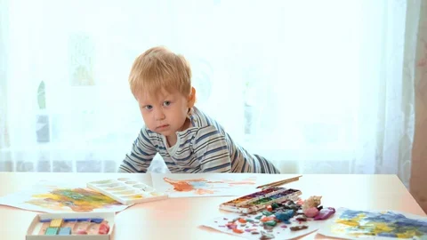 Fair-haired toddler sits at the table and begins to draw. Stock Footage 129148982