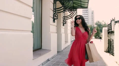 Fair-skinned young lady in red dress walking elegantly down the street Stock-Footage 67867105