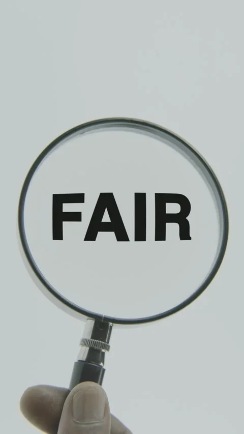 Fair text or word highlighted by a magnifying glass in a hand on a white Stock Footage 303443031