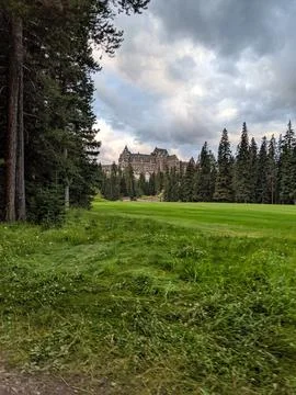 The fairway of a golf course with pine trees and the Banff Springs Hotel Stock Photos