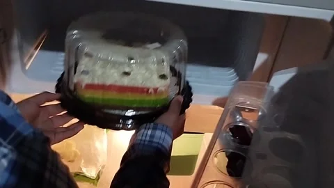 Fajri put the cake in the freezer Stock Footage 212796158