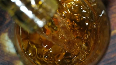 Fake cognac of poor quality poured into a glass, bubbles in alcohol Stock Footage 267006073