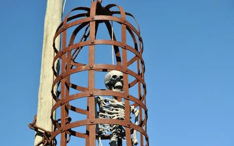 Fake human skeleton hanging inside a metal cage Stock Photos