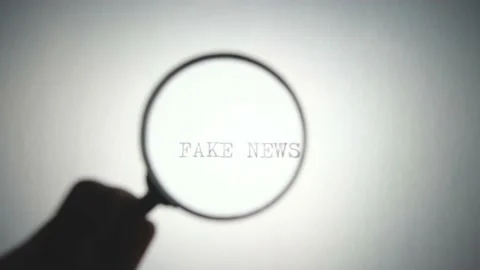 Fake news caption is viewed under a magnifying glass. Stock Footage 144385068