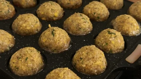 Falafel balls cooking in divided pan, low oil vegetarian food preparation Stock Footage 346778563