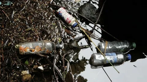 Falkirk,UK -17/07/20:Plastic bottles floating on the side of a river Stock Footage 135737583