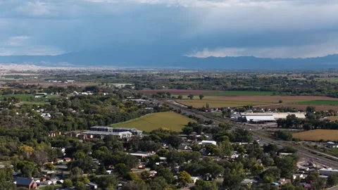 Fall aerial of residential development in Delta Colorado with stormy mountains Stock Footage 347303153