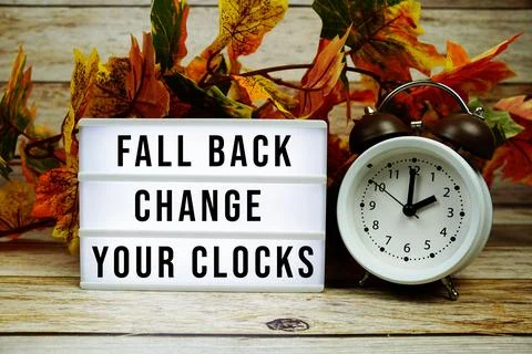 Fall back change your clocks text with alarm clock and maple leaf decoratio.. Stock Photos
