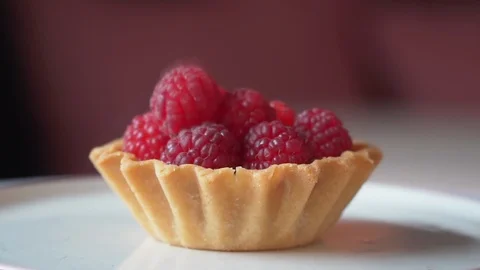 Fall of a berry to raspberry cake slow motion Stock Footage 117688894