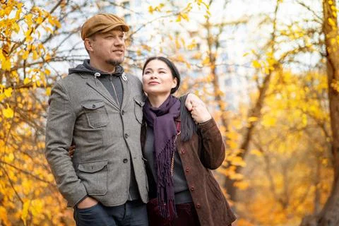 Fall Caucasian Pair is Walking Through the Fall Forest. Casual Couple Walks Stock Photos