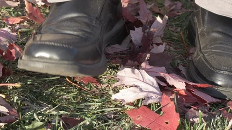 Fall- closeup bored man moving foot up and down on orange maple leaves 4k Stock Footage 97383122